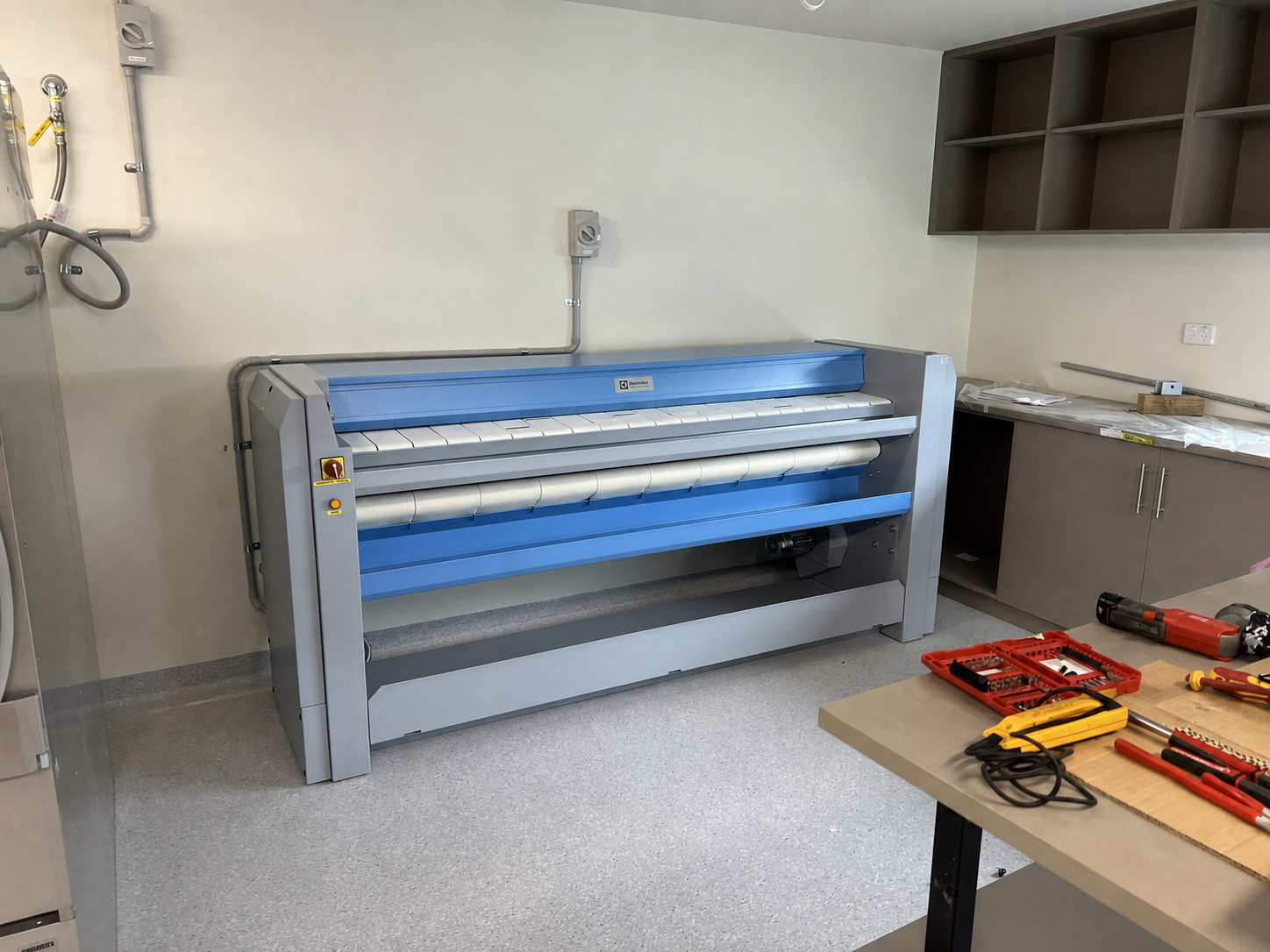 Commercial ironer installed in the hotel laundry finishing area