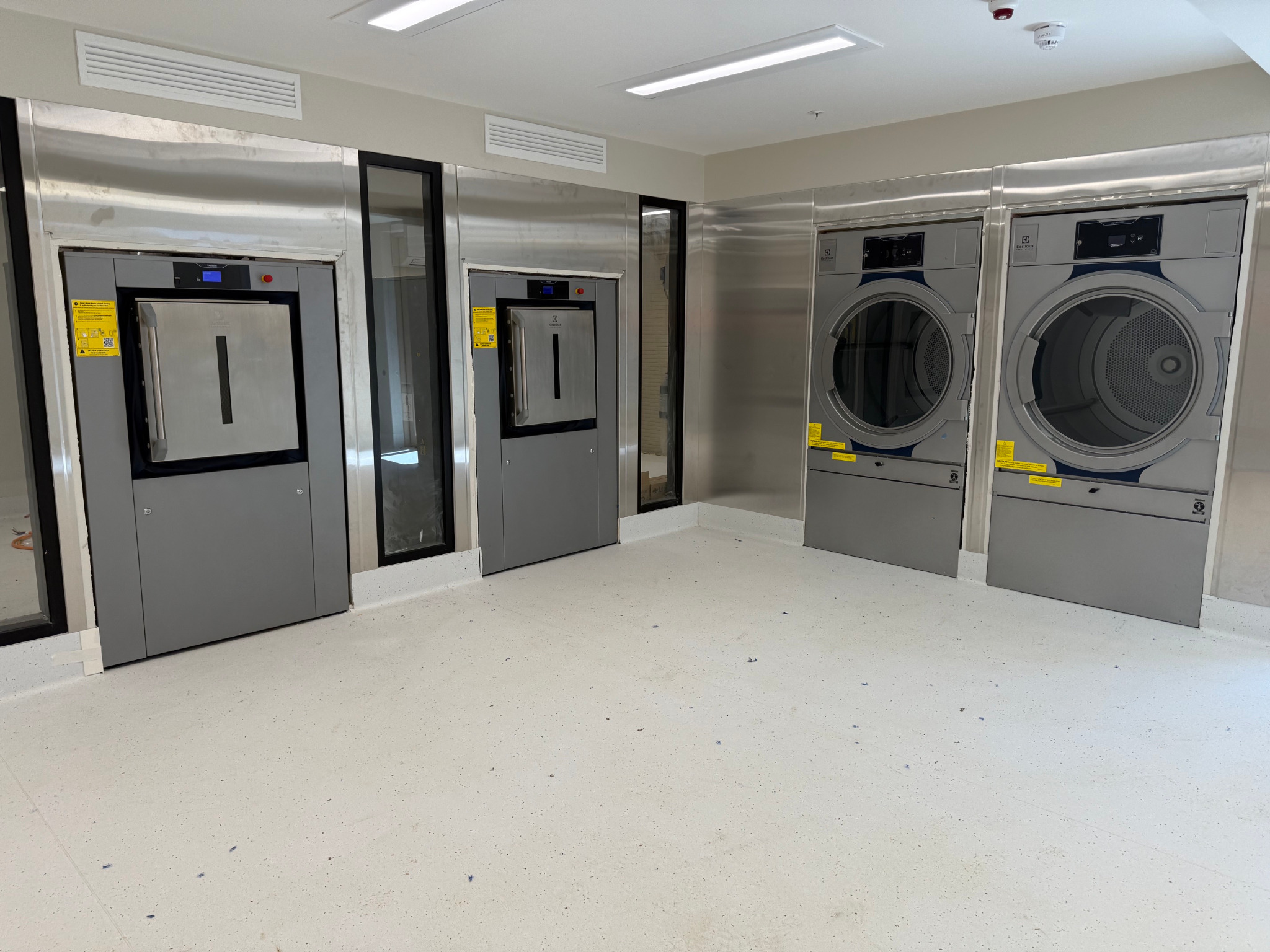 Completed aged care laundry with barrier washer extractors and commercial dryers installed