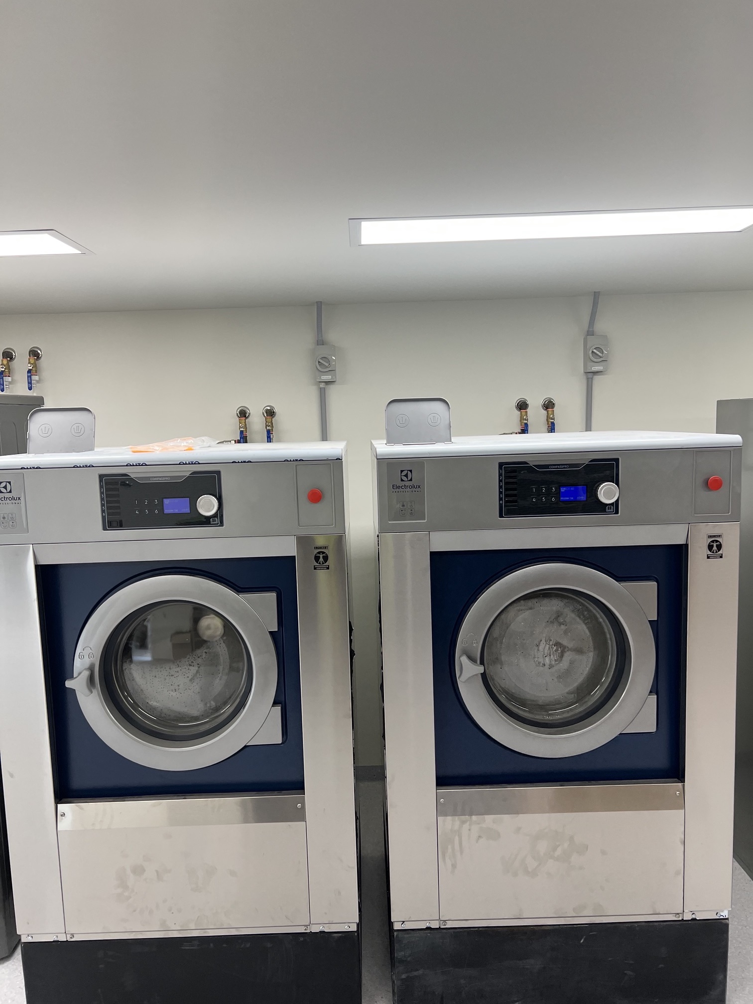 Two commercial washer extractors running in the completed hotel laundry