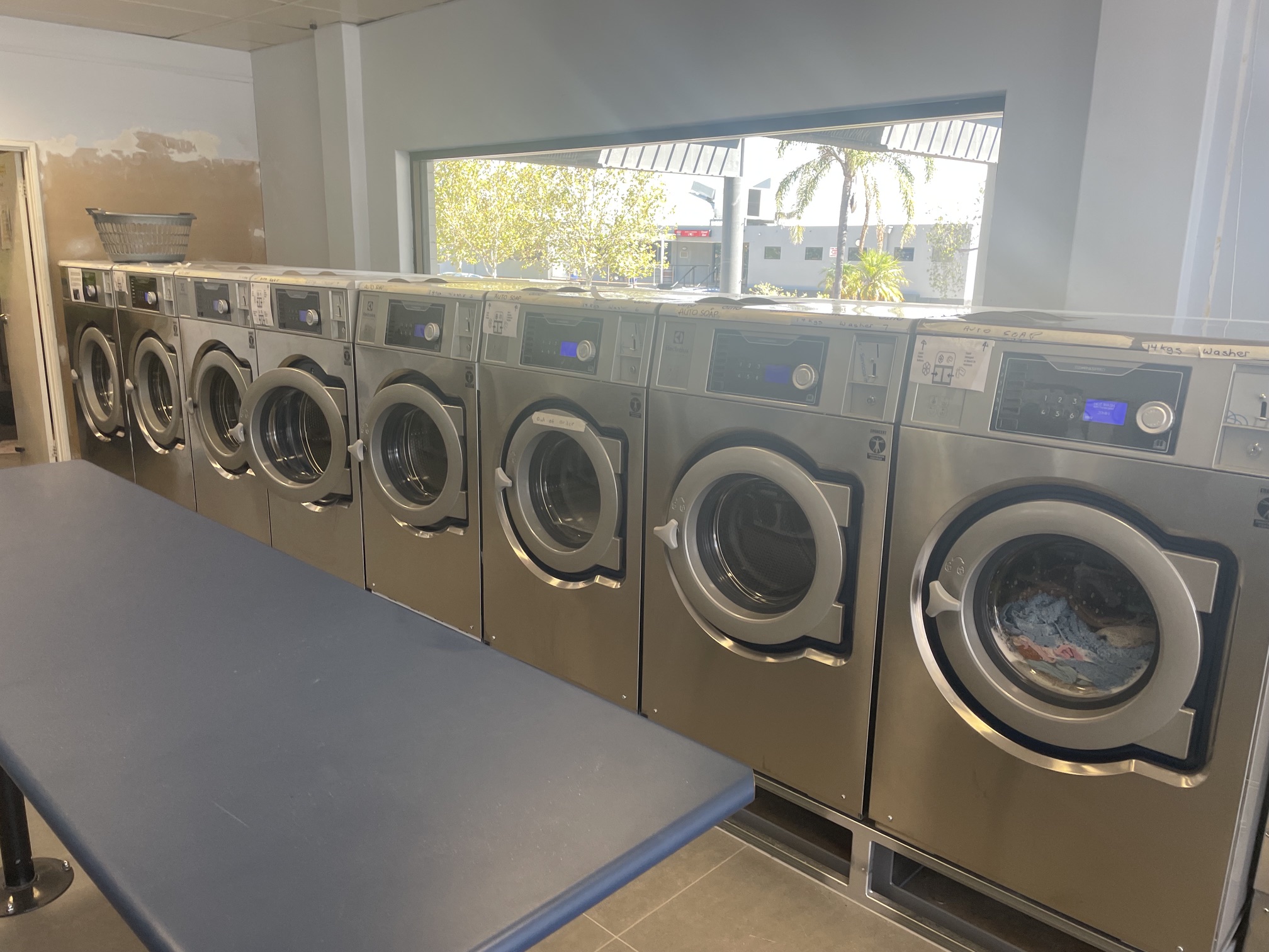 Installed laundromat washer extractors running a wash cycle