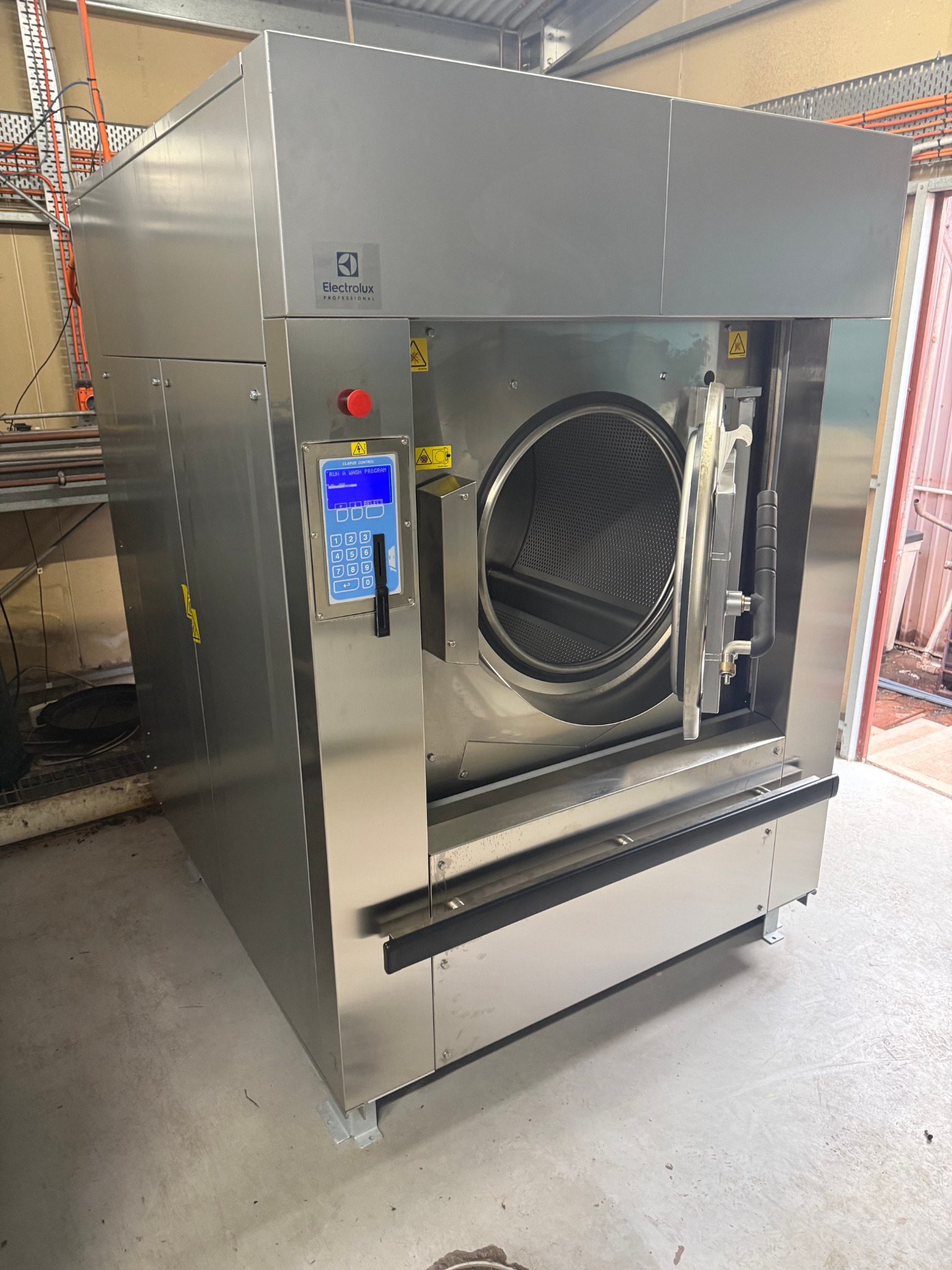 Installed heavy-duty commercial washer extractor with the door open