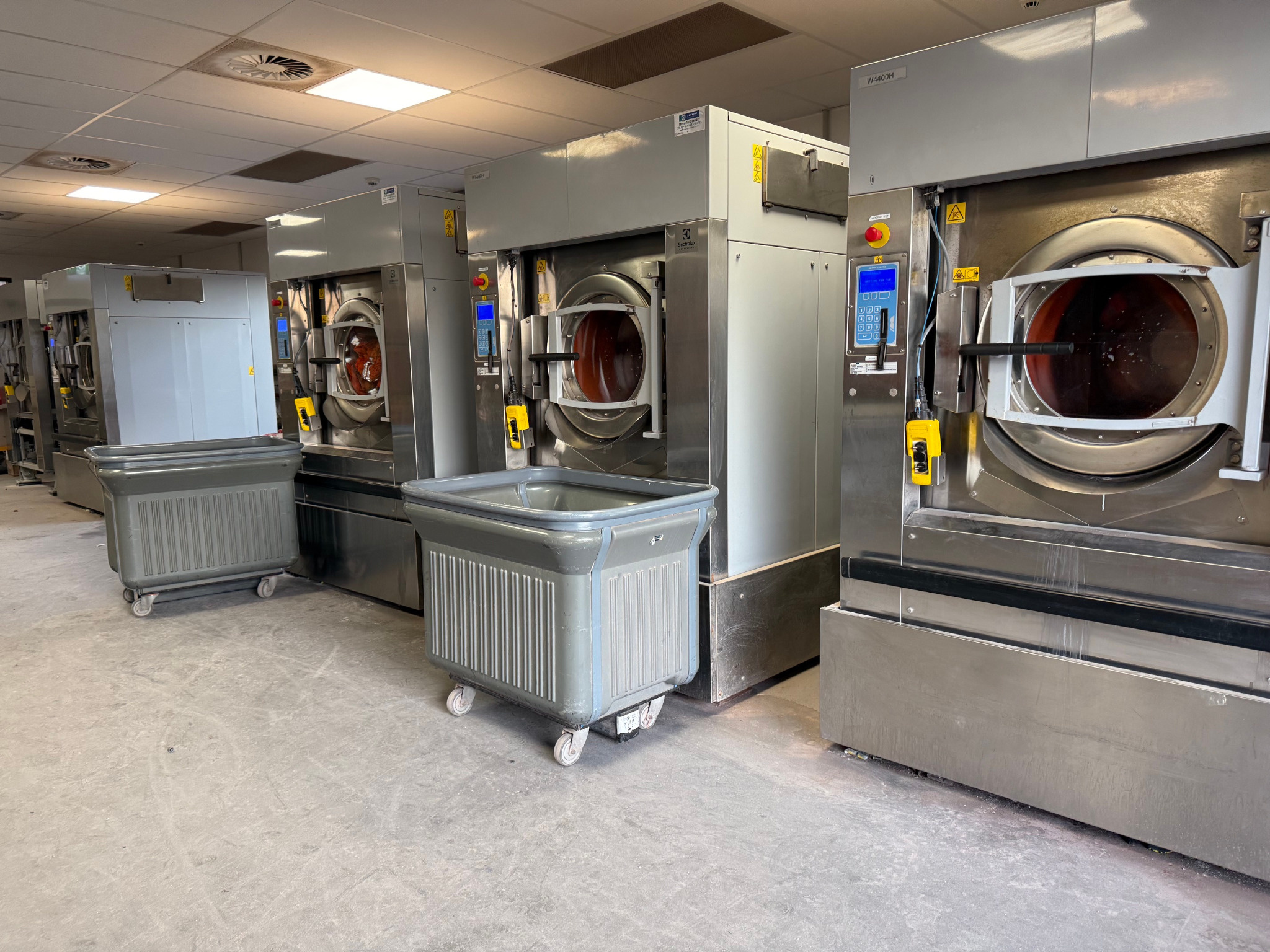 Row of installed heavy-duty washer extractors in a commercial mining laundry